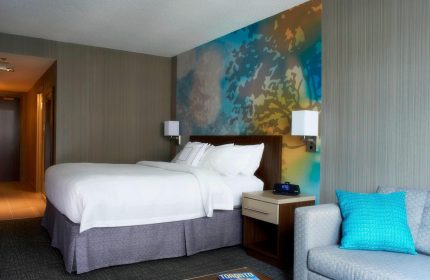 Courtyard by Marriott Toronto Downtown guest room. Gay-friendly hotel with modern decor, comfy bed, and vibrant wall art. Ideal for gay travel.
