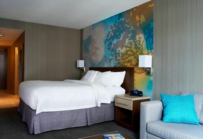 Courtyard by Marriott Toronto Downtown guest room. Gay-friendly hotel with modern decor, comfy bed, and vibrant wall art. Ideal for gay travel.