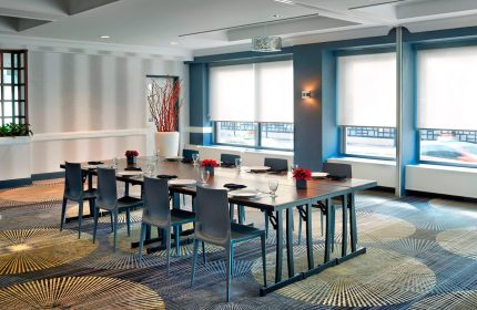 Courtyard by Marriott Toronto Downtown meeting room. Gay-friendly hotel event space with long table, chairs, and modern decor.