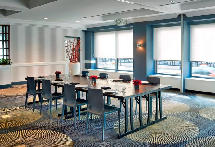 Courtyard by Marriott Toronto Downtown meeting room. Gay-friendly hotel event space with long table, chairs, and modern decor.