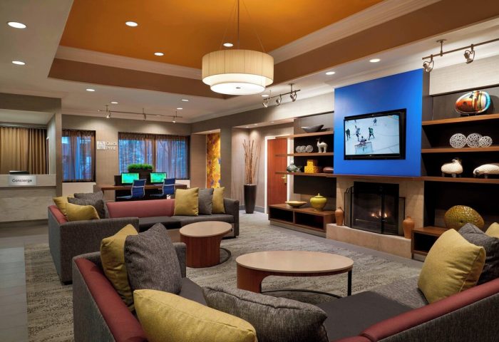 Courtyard by Marriott Toronto Downtown lobby. Gay-friendly hotel with lounge, TV, fireplace, and workspace. Modern interior design.