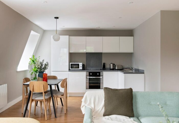 Cove Minshull Street gay-friendly hotel room. Modern kitchen, dining table, and sofa create a welcoming space for gay travelers.