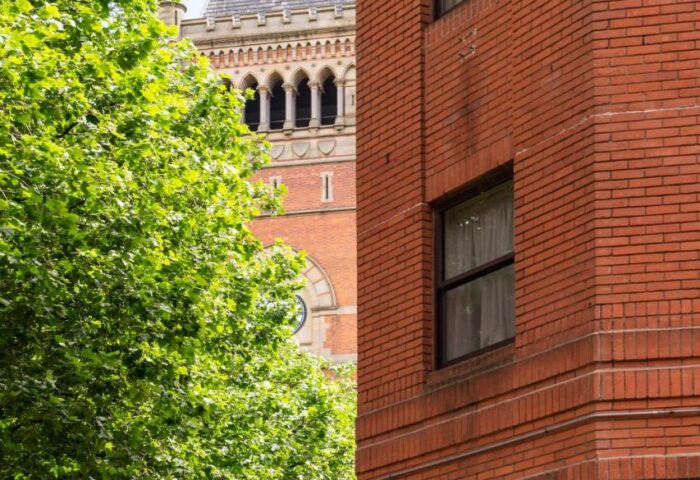 Cove Minshull Street, a gay-friendly hotel. Exterior view of the brick building with a tower in the background. Great for gay travel.