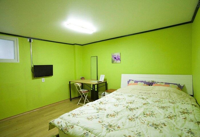 CozyPlace Guesthouse Itaewon room. Gay-friendly hotel featuring a bed, desk, and TV. A comfortable stay for LGBTQ+ travelers in Seoul.