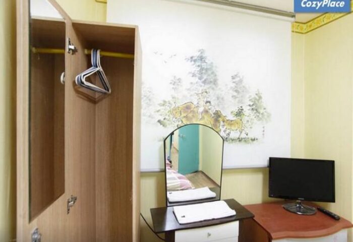 CozyPlace Guesthouse in Itaewon room. Gay-friendly hotel room with wardrobe, mirror, and TV. Comfortable stay in Seoul's gay district.