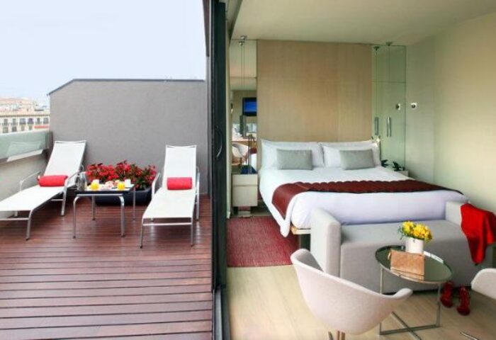 Gay-friendly hotel room with balcony. Modern design, king bed, outdoor seating. Perfect for gay travel, offering luxury and comfort. Cram hotel.