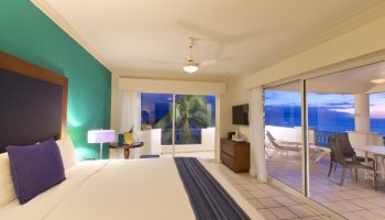 Crown Paradise Golden Adults Only gay-friendly hotel room. Balcony view, ocean, bed, and modern decor. All-inclusive resort for gay men.