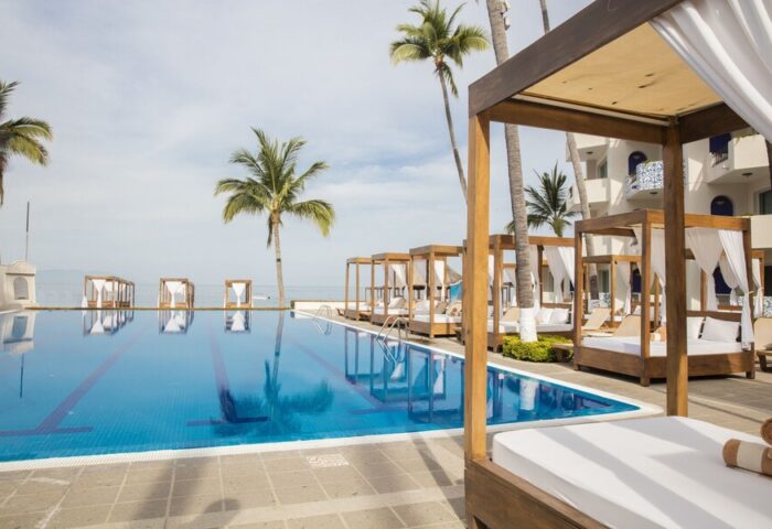 Crown Paradise Golden All Inclusive Adults Only gay-friendly hotel pool with cabanas, palm trees, and ocean view. Ideal for gay travel.