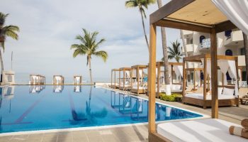 Crown Paradise Golden All Inclusive Adults Only gay-friendly hotel pool with cabanas, palm trees, and ocean view. Ideal for gay travel.