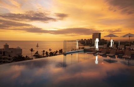 Sunset view from the rooftop pool at Crown Paradise Golden All Inclusive Adults Only, a gay-friendly hotel. Ocean, city skyline.