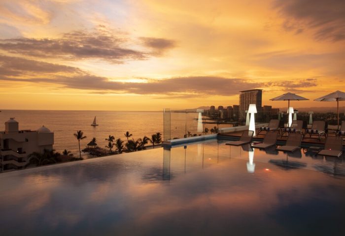 Sunset view from the rooftop pool at Crown Paradise Golden All Inclusive Adults Only, a gay-friendly hotel. Ocean, city skyline.