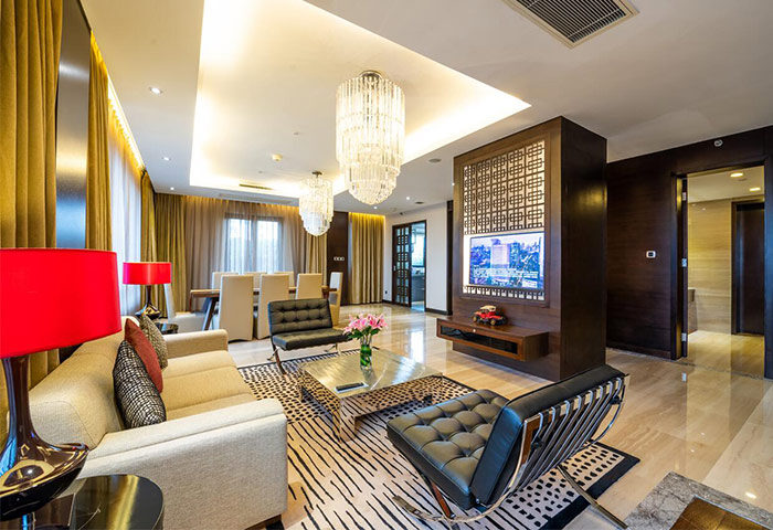 Crowne Plaza Shanghai's Noah Square suite. Gay-friendly hotel living room with modern decor, chandeliers, and a dining area. Upscale Shanghai stay.