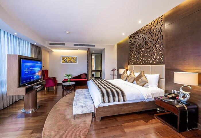 Crowne Plaza Shanghai bedroom interior. Gay-friendly hotel with bed, TV, sofa, and stylish decor. Noah's Square stay for LGBTQ+ travelers in Shanghai.