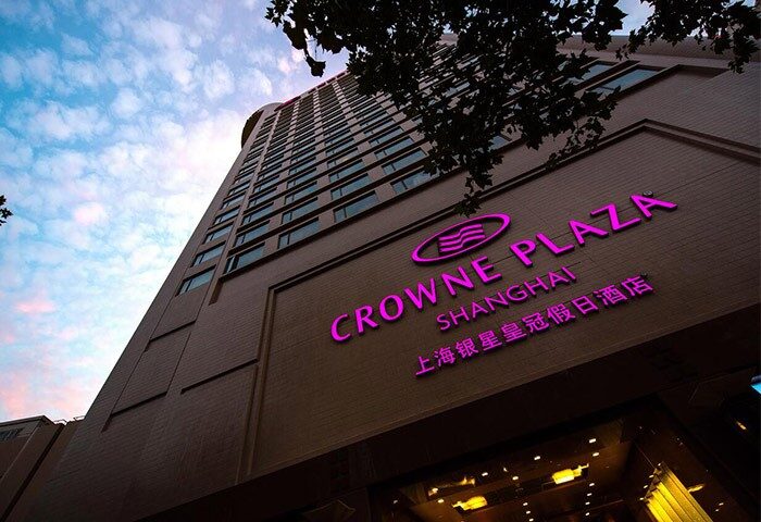 Crowne Plaza Shanghai, a gay-friendly hotel near Noah's Square. View of the hotel's exterior with its illuminated signage.