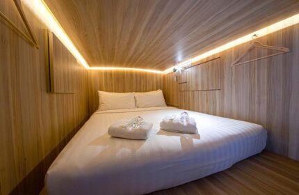 Cube Boutique Capsule Hotel @ Chinatown interior. Gay-friendly hotel capsule with double bed, towels, and wooden walls. Chinatown lodging.