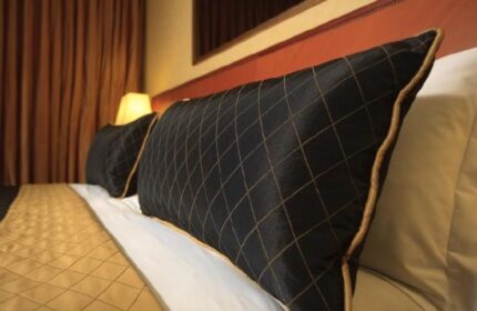 Dan Tel Aviv Hotel room detail. Gay-friendly hotel with stylish black and gold patterned pillows, inviting gay travelers for a luxurious stay.