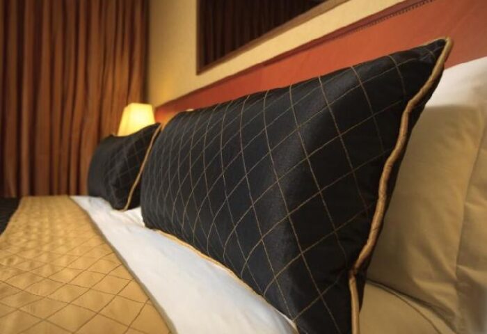 Dan Tel Aviv Hotel room detail. Gay-friendly hotel with stylish black and gold patterned pillows, inviting gay travelers for a luxurious stay.