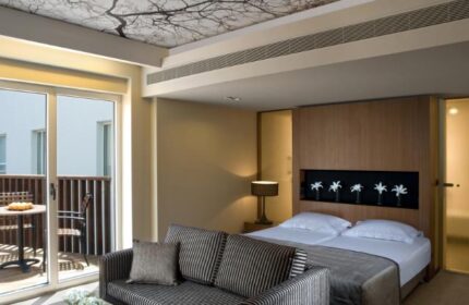 Dan Tel Aviv Hotel room with balcony. Gay-friendly hotel with modern design, tree-themed ceiling, and comfortable bed. Great for gay travel.