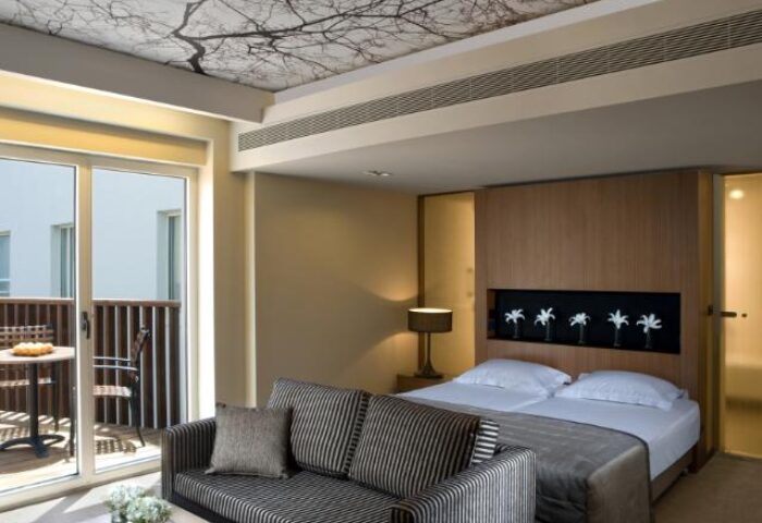 Dan Tel Aviv Hotel room with balcony. Gay-friendly hotel with modern design, tree-themed ceiling, and comfortable bed. Great for gay travel.