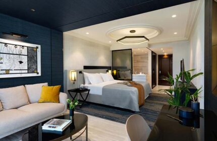 Dan Tel Aviv Hotel room. Gay-friendly hotel features a modern design, comfortable bed, seating area, desk, and bathroom. Upscale travel.