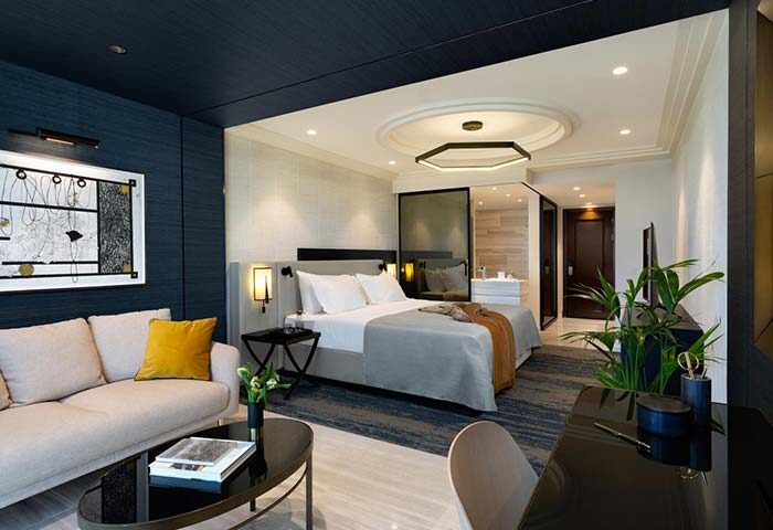Dan Tel Aviv Hotel room. Gay-friendly hotel features a modern design, comfortable bed, seating area, desk, and bathroom. Upscale travel.