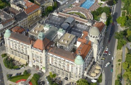 Aerial view of the Gay-Friendly Danubius Hotel Gellert in Budapest. The hotel features a pool and outdoor seating. Gay travel advice.