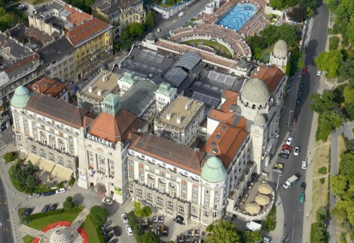 Aerial view of the Gay-Friendly Danubius Hotel Gellert in Budapest. The hotel features a pool and outdoor seating. Gay travel advice.
