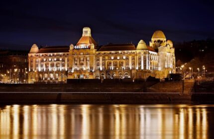Danubius Hotel Gellert at night. Gay-friendly hotel in Budapest, Hungary, with illuminated facade and river reflection. Recomended for gay travelers.