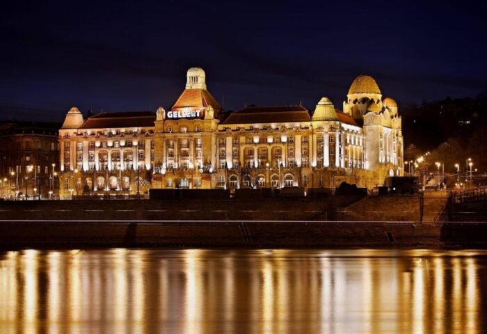 Danubius Hotel Gellert at night. Gay-friendly hotel in Budapest, Hungary, with illuminated facade and river reflection. Recomended for gay travelers.