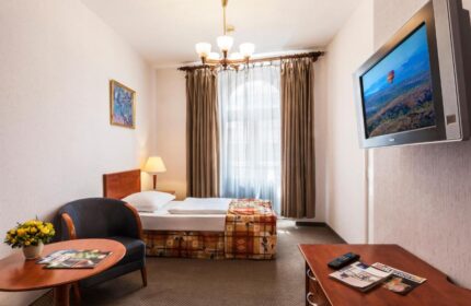 Danubius Hotel Gellert room. Gay-friendly hotel with single bed, chair, table, and TV. Budapest hotel for gay men travelers.