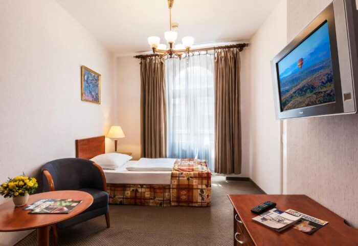 Danubius Hotel Gellert room. Gay-friendly hotel with single bed, chair, table, and TV. Budapest hotel for gay men travelers.