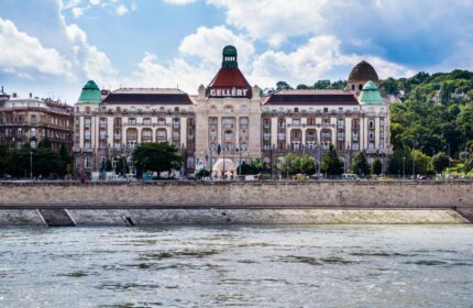 Danubius Hotel Gellert, a gay-friendly hotel in Budapest. The Gellert Spa hotel is seen from across the Danube River. Gay travel advice.