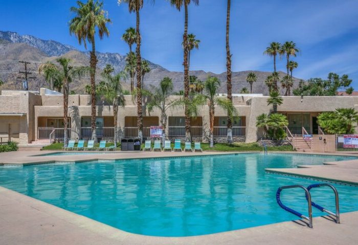 Days Inn by Wyndham Palm Springs pool view. Gay-friendly hotel with mountain backdrop, palm trees, and inviting turquoise pool. Perfect for a gay vacation.
