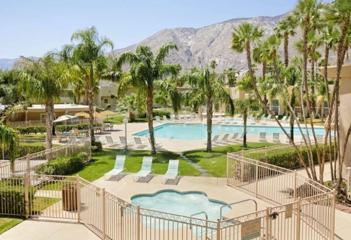 Days Inn by Wyndham Palm Springs pool and hot tub. Gay-friendly hotel with mountain views and palm trees. Ideal for gay travel.