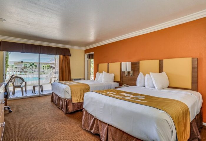 Days Inn by Wyndham Palm Springs guest room with two beds. View of pool. Gay-friendly hotel for gay men travelers.