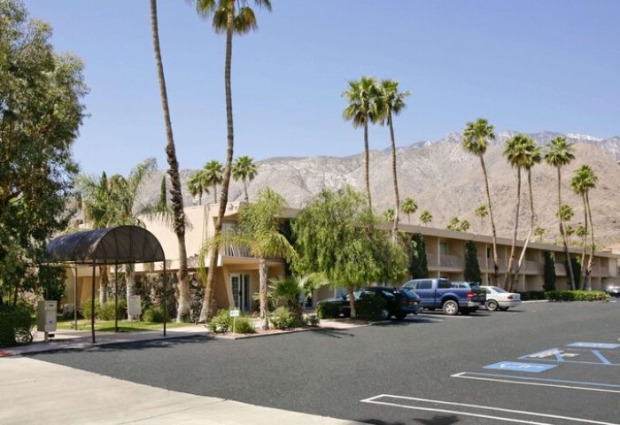 Days Inn by Wyndham Palm Springs, a gay-friendly hotel. Features palm trees, mountain views, parking, and accessible parking spaces.
