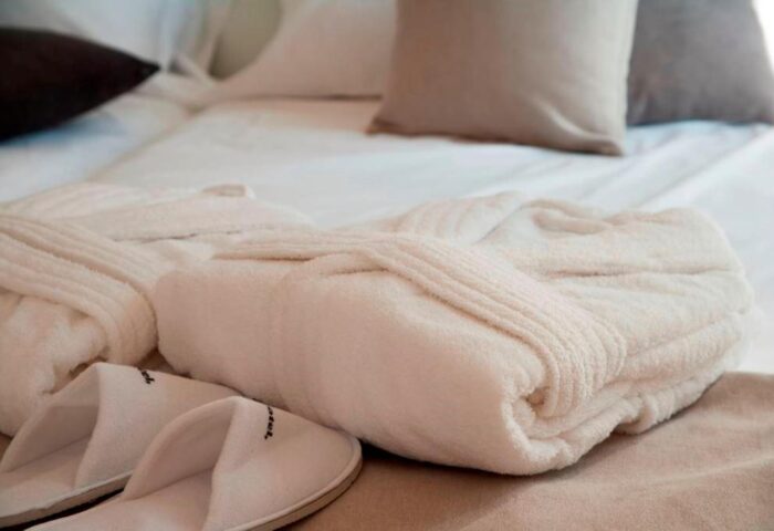 Dear Hotel Madrid: Bathrobes and slippers on a bed. Gay-friendly hotel amenities for a comfortable stay in Madrid, Spain.