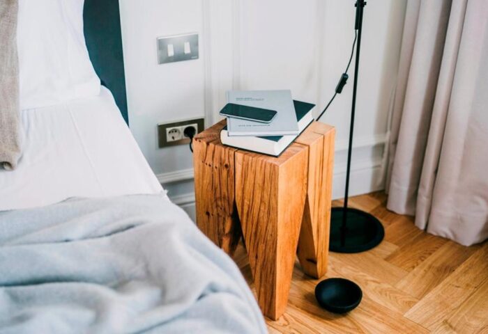 Dear Hotel Madrid detail: bedside table with books and phone. Gay-friendly hotel room interior, modern design. Madrid travel advice.