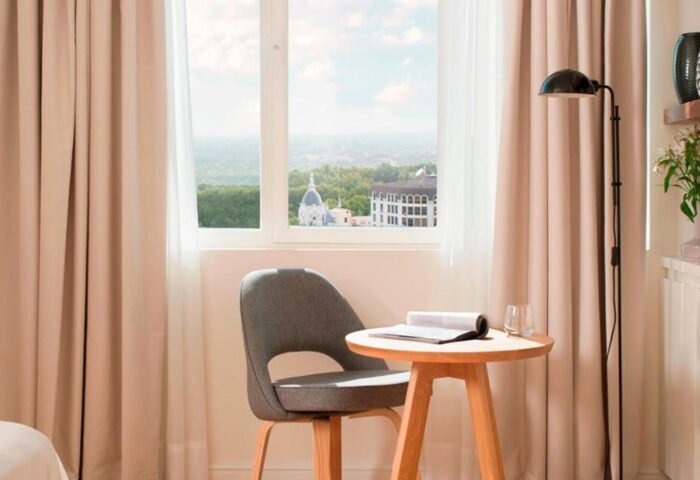 Dear Hotel Madrid room interior. Gay-friendly hotel room with chair, table, lamp, and view. A modern, comfortable space for gay travelers in Madrid.