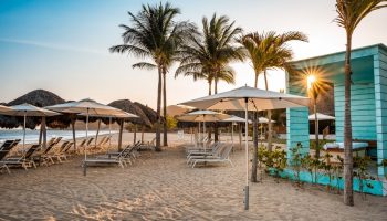 Gay-friendly Delta Hotels by Marriott Riviera Nayarit All-Inclusive beach. Loungers, umbrellas, and palm trees at a gay resort.