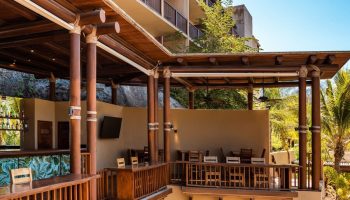 Delta Hotels by Marriott Riviera Nayarit All-Inclusive bar area. Gay-friendly hotel with wooden decor, tables, and a relaxed atmosphere.