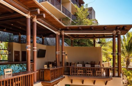 Delta Hotels by Marriott Riviera Nayarit All-Inclusive bar area. Gay-friendly hotel with wooden decor, tables, and a relaxed atmosphere.