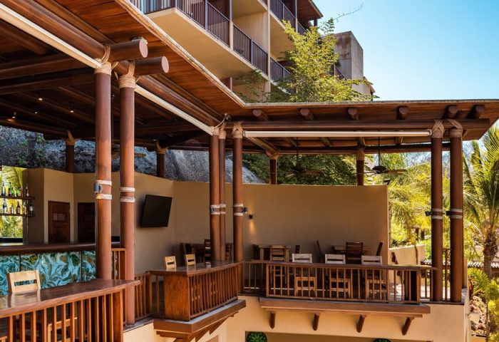 Delta Hotels by Marriott Riviera Nayarit All-Inclusive bar area. Gay-friendly hotel with wooden decor, tables, and a relaxed atmosphere.