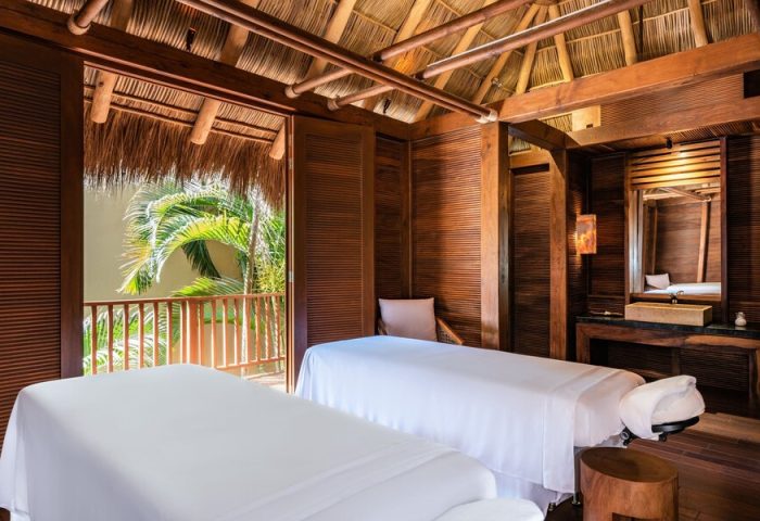 Spa room at Delta Hotels by Marriott Riviera Nayarit All-Inclusive, a gay-friendly hotel. Two massage beds, wood decor, and tropical view.