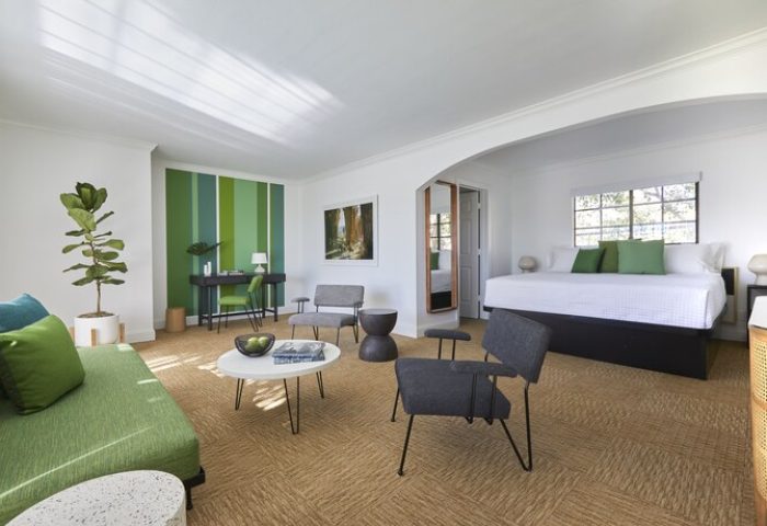 Descanso Resort, a gay-friendly men's resort. Room interior with green accents, modern furniture, and a comfortable daybed. Relaxing getaway.
