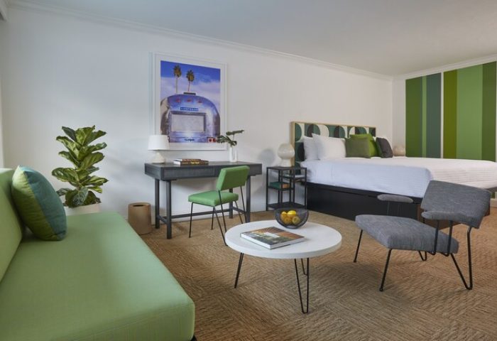 Descanso Resort, a men's resort, gay-friendly hotel room. Modern decor, green accents, bed, desk, and seating area. Relaxing travel.