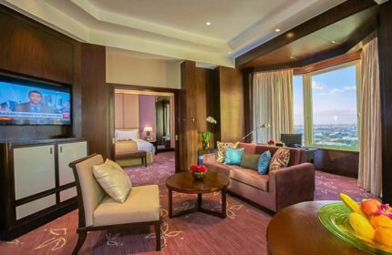 Diamond Hotel suite. Gay-friendly hotel with living room, TV, and bedroom view. Luxury travel for gay men. Hotel room interior.