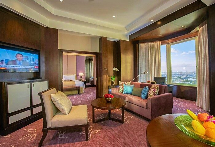 Diamond Hotel suite. Gay-friendly hotel with living room, TV, and bedroom view. Luxury travel for gay men. Hotel room interior.