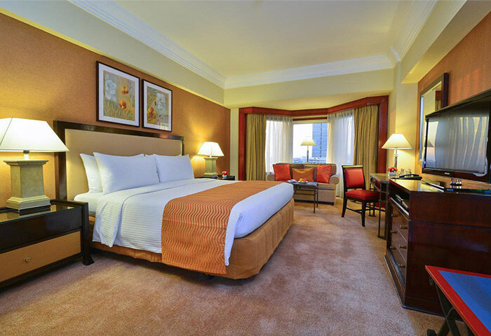 Gay-friendly Diamond Hotel room. Luxury suite with king bed, sitting area, and city view. A comfortable and welcoming space for gay travelers.