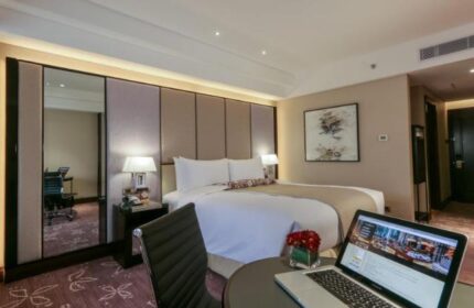 Diamond Hotel room: Laptop on desk, king bed, workspace, and modern decor. Gay-friendly hotel for gay men travel advice and booking.